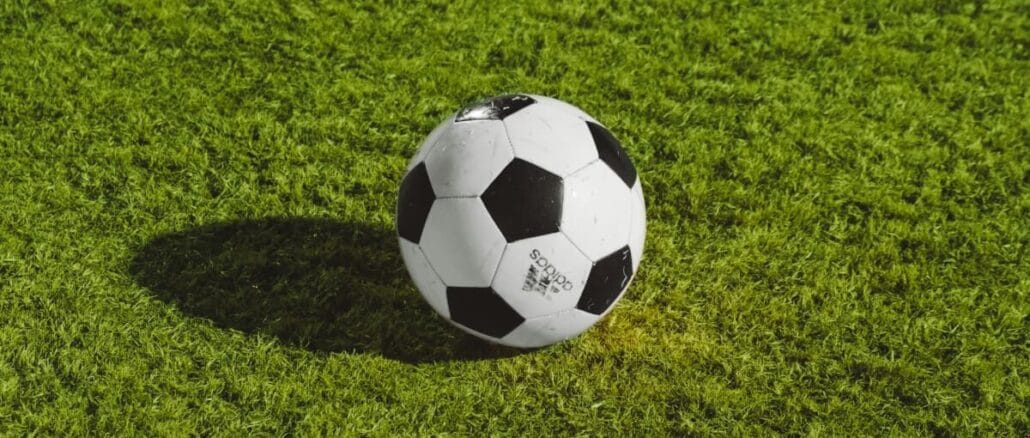 Svart och vit boll på fotbollsplanen.